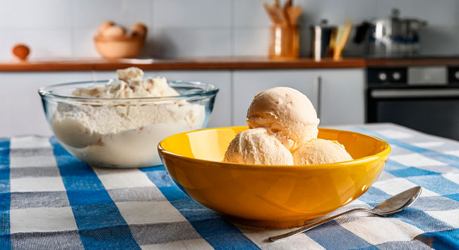 Uma tigela amarela com bolas de sorvetes caseiros.