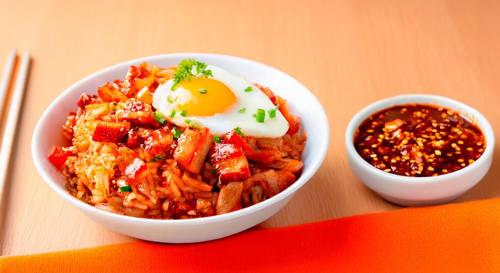 Prato de arroz com ovo, carne e molho picante.