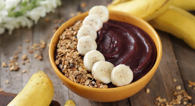 Açaí na tigela servido com pedaços de banana e granola.