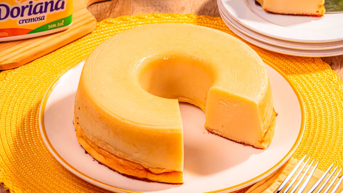 bolo mole dourado com textura cremosa, servido em prato branco sobre toalha amarela, ao lado de margarina Doriana.