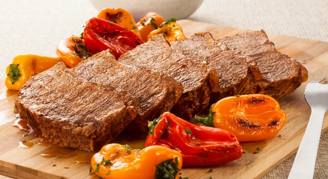 Contrafilé fatiado e servido com legumes grelhados.