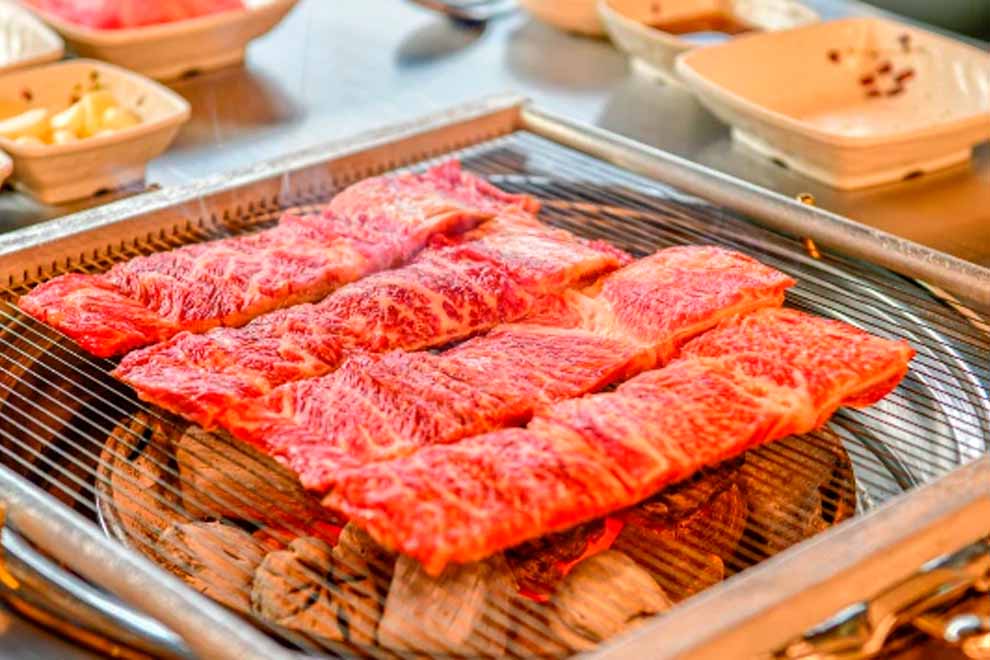 Carne suculenta sendo grelhada na churrasqueira