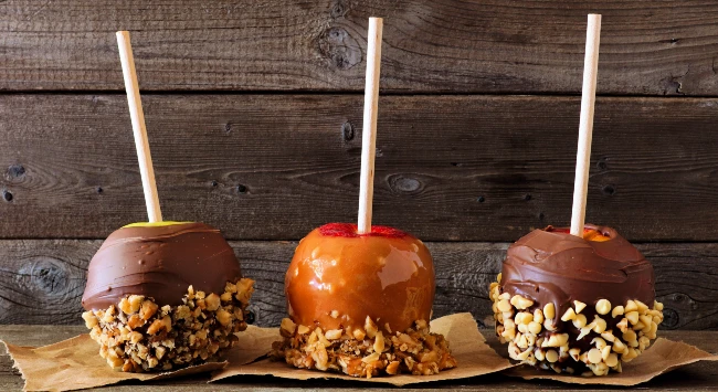 Maçã do amor coberta com chocolate e castanhas.