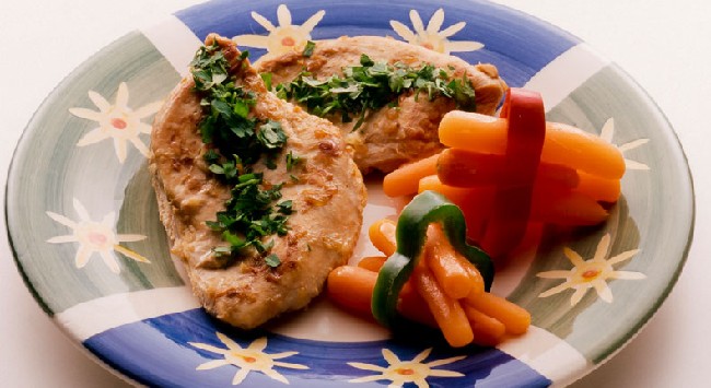 Filés de frango com salsinha um mini cenouras presas em fatias de pimentão.