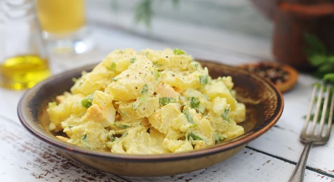 salada de batata alemã servida em prato de madeira