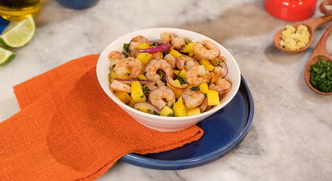 salada de camarão, manga e cebola roxa servida em tigela branca