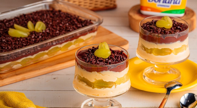 Surpresa de uva: uvas verdes, creme branco, ganache de chocolate e granulado, servida em travessa e taças individuais decoradas.