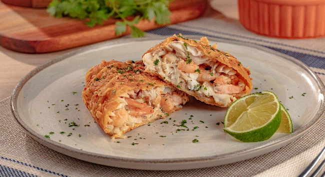 Filés de tilápia recheados com camarão servidos em um prato cinza. 